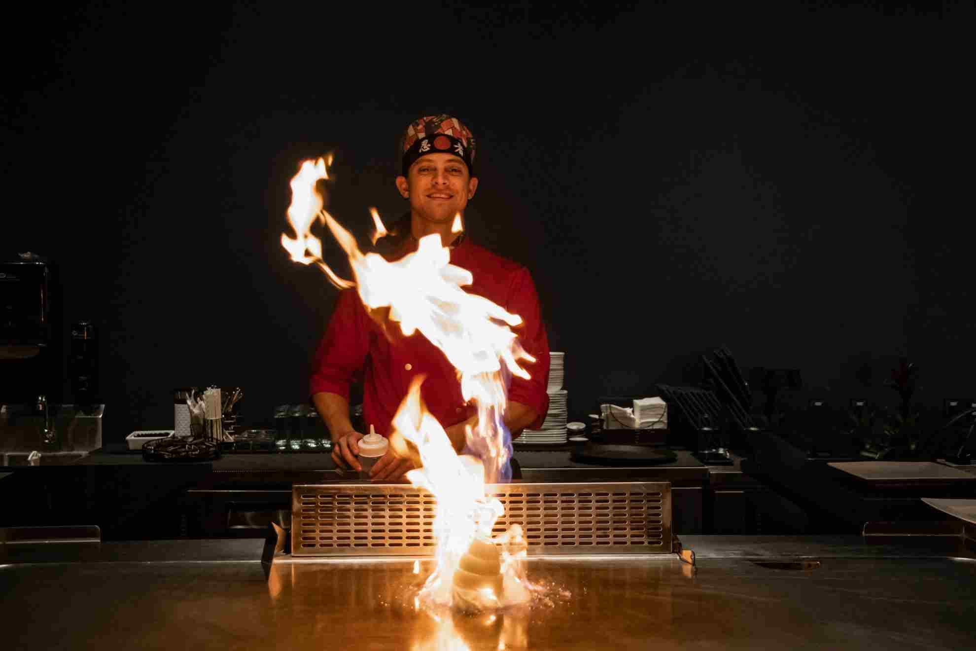 A Kasai chef behind a rising column of flame at the teppanyaki grill